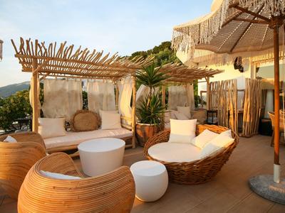 Outdoor-Lounge-Bereich mit bequemen Sitzmöbeln, Sonnenschirmen und malerischer Aussicht.