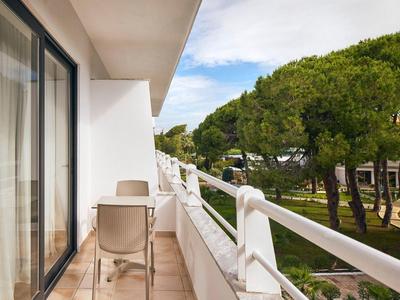 Balkon mit Stühlen und Blick auf grüne Bäume in einem Hotel