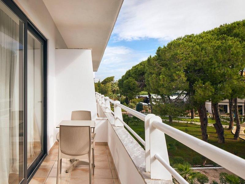 Balkon mit Stühlen und Blick auf grüne Bäume in einem Hotel