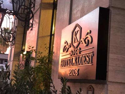 Insegna illuminata dell'hotel Kodest su una parete dell'edificio al crepuscolo.