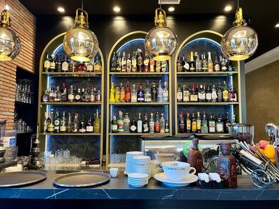 Półka z różnymi butelkami alkoholu i szklankami w barze