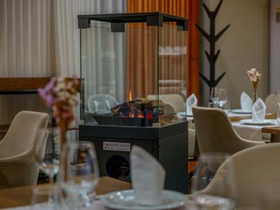 Chauffage moderne avec enceinte en verre dans un cadre élégant de restaurant d'hôtel avec tables dressées.