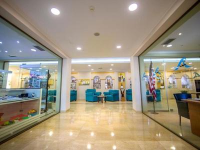 Area lobby di un hotel moderno con posti a sedere e pareti di vetro ai lati.