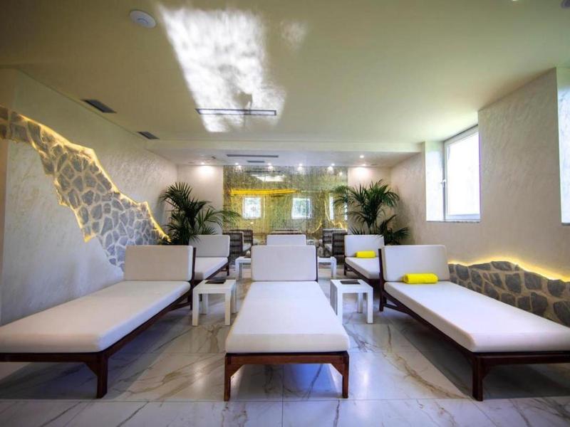 Nowoczesny pokój wellness z leżakami i nastrojowym oświetleniem na ścianach.