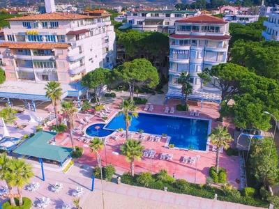 Luftaufnahme einer Wohnanlage mit Pool, umgeben von Bäumen und mehrstöckigen Gebäuden.