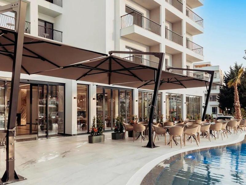 Area hotel moderna con piscina e posti a sedere all'aperto sotto ombrelloni di giorno