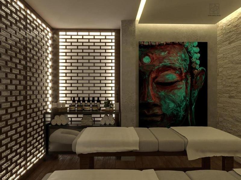 Sala benessere moderna con due lettini da massaggio e parete illuminata.