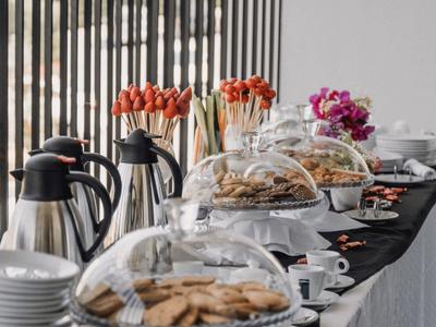 Un tavolo buffet con biscotti assortiti e caffè in una stanza luminosa.
