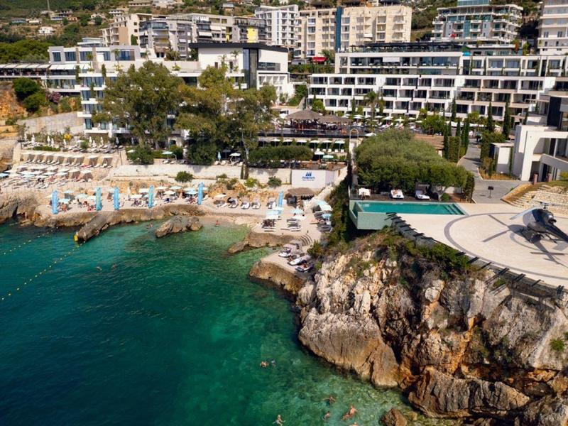Hotel di lusso sul mare con eliporto privato e costa rocciosa.