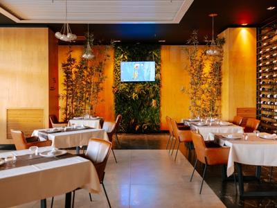 Restaurant élégant avec tables dressées et ambiance lumineuse chaleureuse