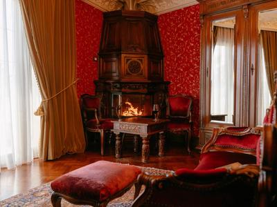 Gezellige woonkamer met rode inrichting, open haard en klassieke houten meubels.