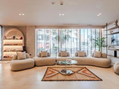 Moderner Sitzbereich mit geschwungenen Sofas und Teppich vor bodentiefen Fenstern.