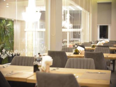 Elegant restaurant with set tables and modern lighting in a hotel.