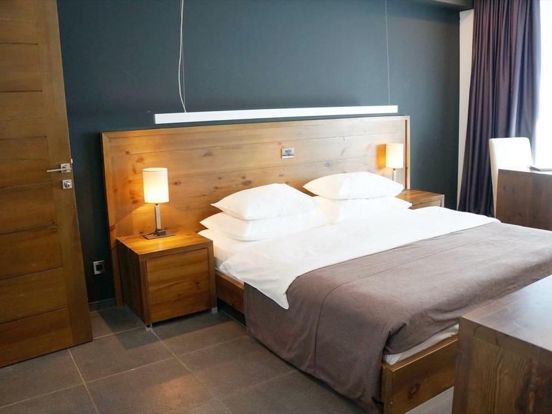 Habitación de hotel acogedora con cama doble, muebles de madera y luz cálida, sencilla y acogedora.