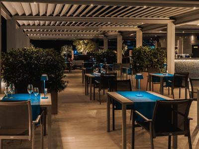 Ambiente elegante de restaurante con manteles azules, sillas y iluminación tenue para noches inolvidables.