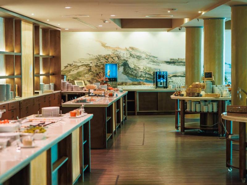 Área de buffet con una variedad de alimentos en un restaurante de hotel elegante y moderno.