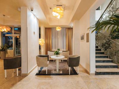 Elegante hotellobby met moderne zithoek en sierlijke trap.