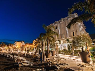 Hotelterras met gesloten parasols en palmbomen 's nachts.