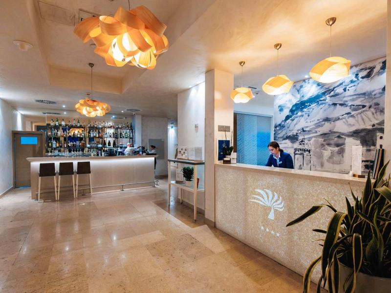 Moderne hotelreceptie met heldere verlichting, stijlvolle lampen en baliepersoneel.