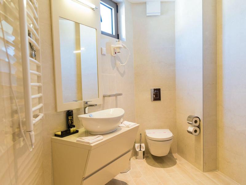 Bright, modern bathroom with sink, toilet, and large mirrors.
