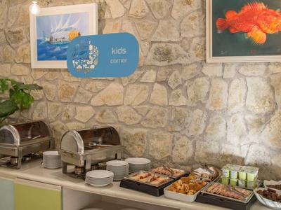 Buffet-Tisch mit Frühstücksoptionen vor einer Steinwand in einem Hotel