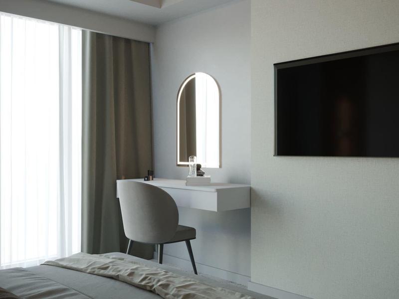 Camera d'hotel minimalista con specchio a parete, TV e seduta comoda.