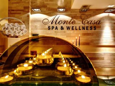Área de spa acogedora con velas y revestimiento de madera en Monte Casa Spa.