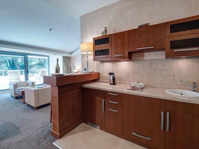 Cocina moderna con frente de madera en un apartamento vacacional con vista a la sala.