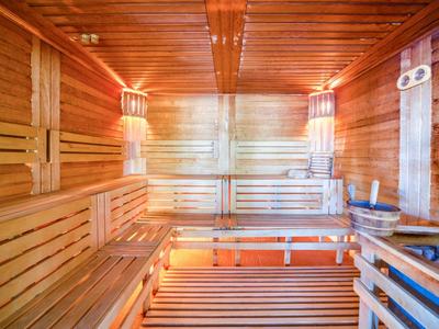 Innere Sauna mit Holzverkleidung, Holzbänken und warmem Licht