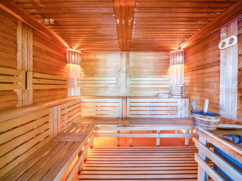 Innere Sauna mit Holzverkleidung, Holzbänken und warmem Licht
