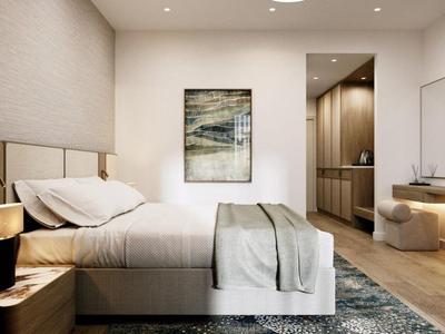 Modern gestaltetes Hotelzimmer mit großem Bett, Kunstwerk an der Wand und Fernseher.