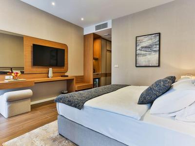 Modern eingerichtetes Hotelzimmer mit Bett, Fernseher und elegantem Schreibtisch.