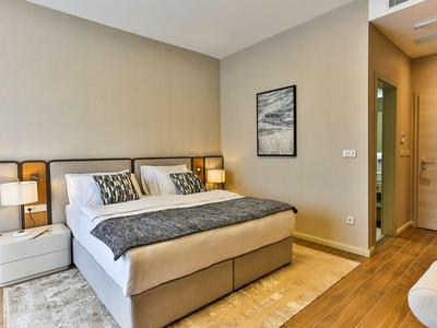 Modernes Hotelzimmer mit großem Doppelbett, Nachttischen, Lampen und Holzboden.