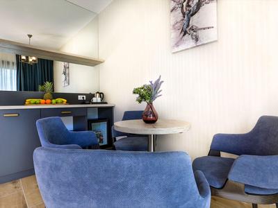 Gemütliche Sitzecke mit blauen Sesseln und kleinem runden Tisch vor der Küchenbar.