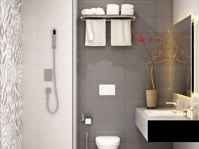 Moderner Badebereich mit grauen Fliesen, hängendem WC, Duschkabine, Handtücher und Pflanzen.