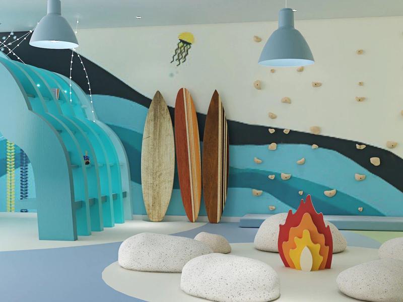 Ein Spielbereich mit blauer Rutsche, drei Surfboards an der Wand und Sitzkissen rund um ein Feuer-Deko.