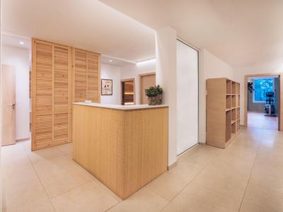 Hotelrezeption mit Holztheke und heller, moderner Einrichtung in warmen Tönen.