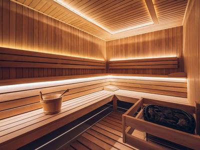Moderne Sauna mit Holzverkleidung, Bänken und Eimer zur Entspannung.
