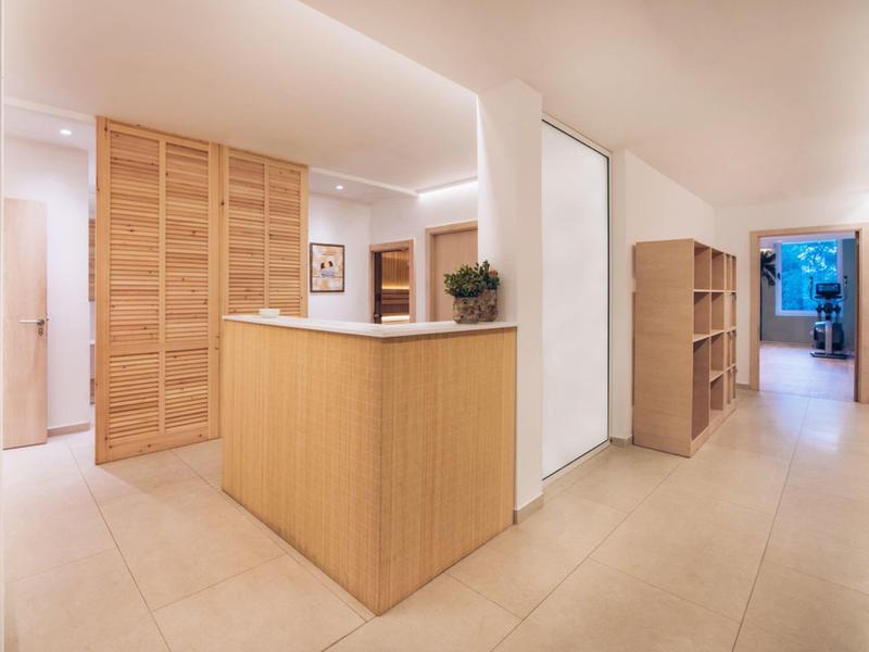 Nowoczesna recepcja hotelowa z drewnianym biurkiem i półkami w jasnym, czystym korytarzu.