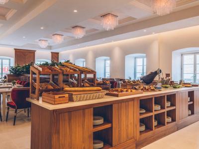 Bright breakfast room with buffet area and wooden shelving.