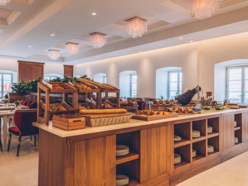 Bright breakfast room with buffet area and wooden shelving.