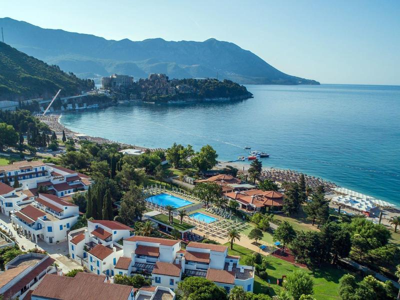Küstenhotel mit Pools, grünen Gärten und Blick auf das Meer und die Berge