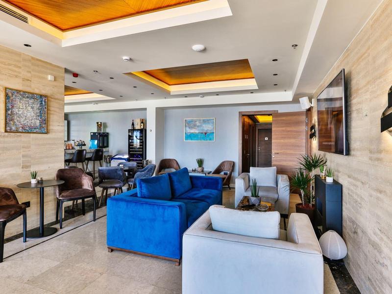 Helles Wohnzimmer mit weißen und blauen Sofas, Glastisch und warmen Holzdeckenakzenten.