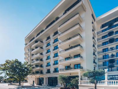 Moderner Hotelkomplex mit Balkonen und klarem blauem Himmel.