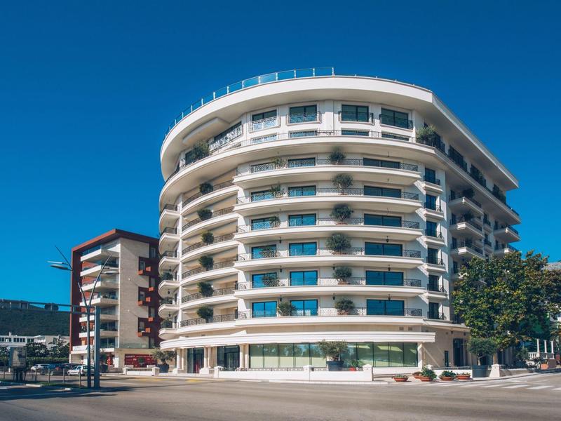 Modernes rundes Hotelgebäude mit Balkonen unter klarem blauem Himmel