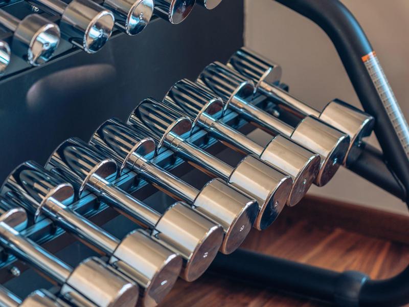 Nahaufnahme eines Hantelsets aus verchromtem Metall in einem Fitnessraum