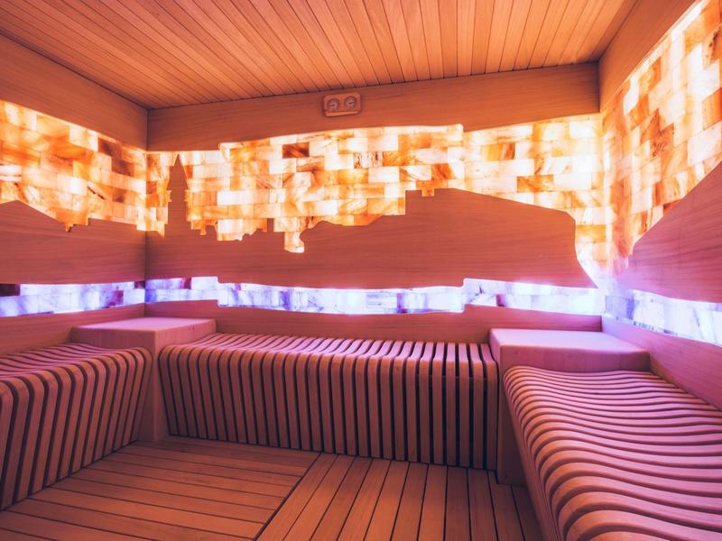 Gemütlicher Ruheraum mit bequemen gepolsterten Sitzen und warmem Ambiente in sanften Orange- und Brauntönen.