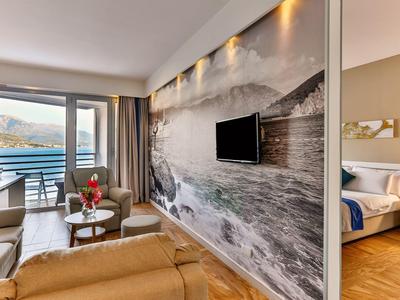 Nowoczesne lobby hotelowe z widokiem na jezioro i góry przez duże okna.