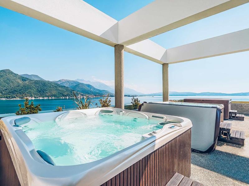 Hot tub on terrace with sea view and mountains in the background