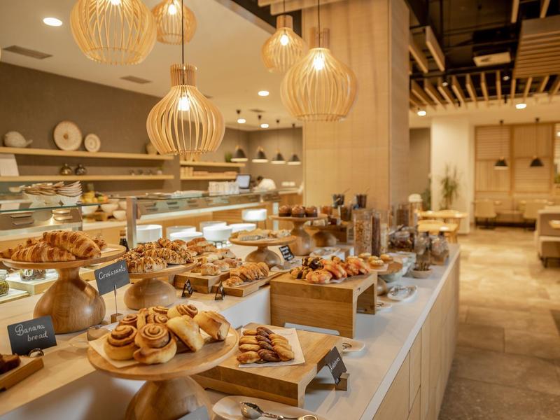 Buffet avec diverses pâtisseries et croissants dans un restaurant d'hôtel moderne.